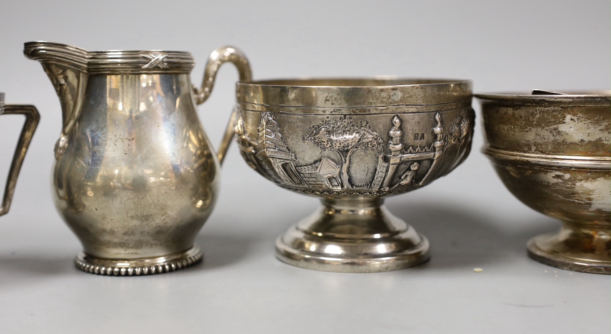 Mixed silver and white metal items including par of toastracks, sugar bowl match sleeve, sauceboat, cream jug, Victorian christening mug, pair of silver mounted clothes brushes, silver mustard silver cigarette case, 25.8